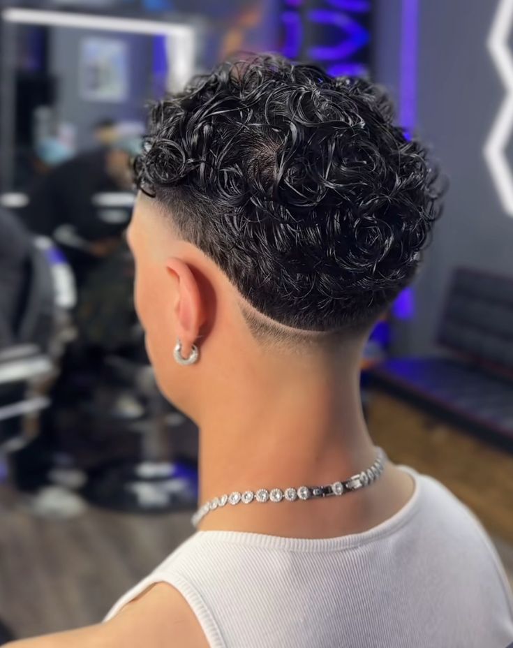 Corte moderno de cabello para hombre taper fade con diseño de líneas paralelas sutiles.