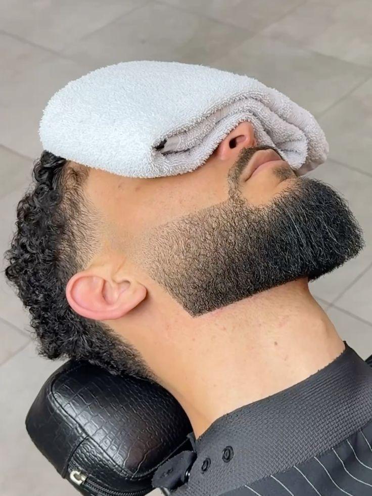 Ritual de perfilado de barba con navaja en barber shop latino.
